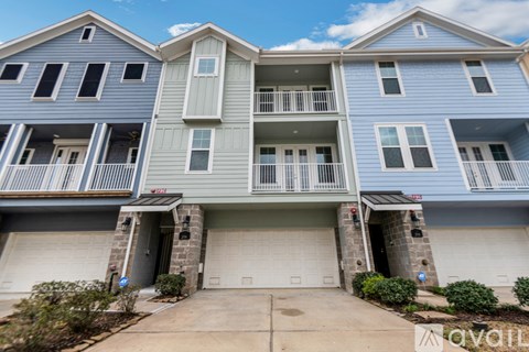 A two-story apartment building with a garage on the ground floor.