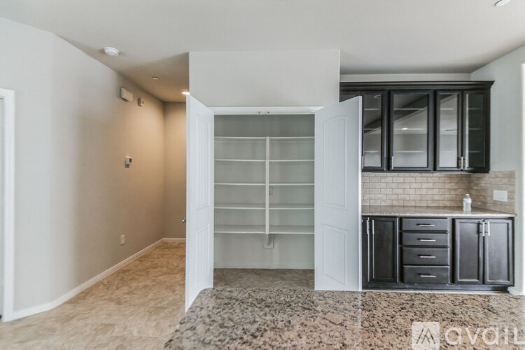 A kitchen area with a white cabinet and a glass door cabinet.