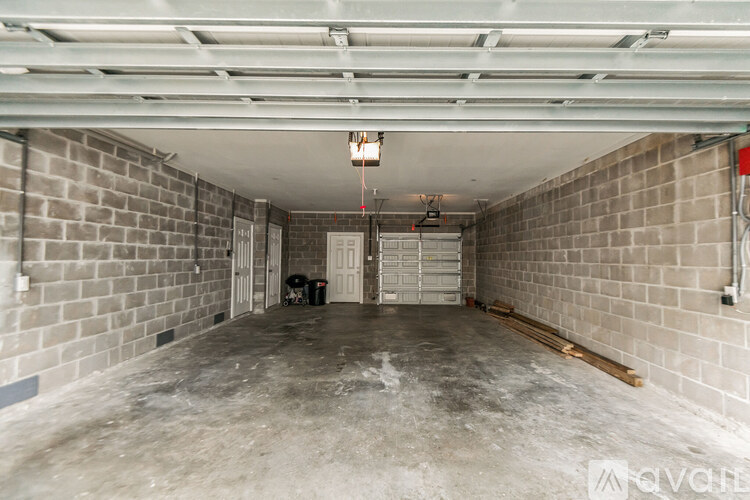 A spacious, unfinished basement with concrete floors and brick walls.