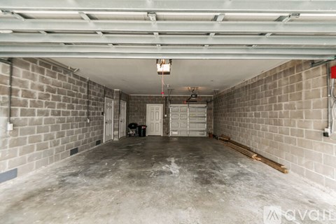 A spacious, unfinished basement with concrete floors and brick walls.