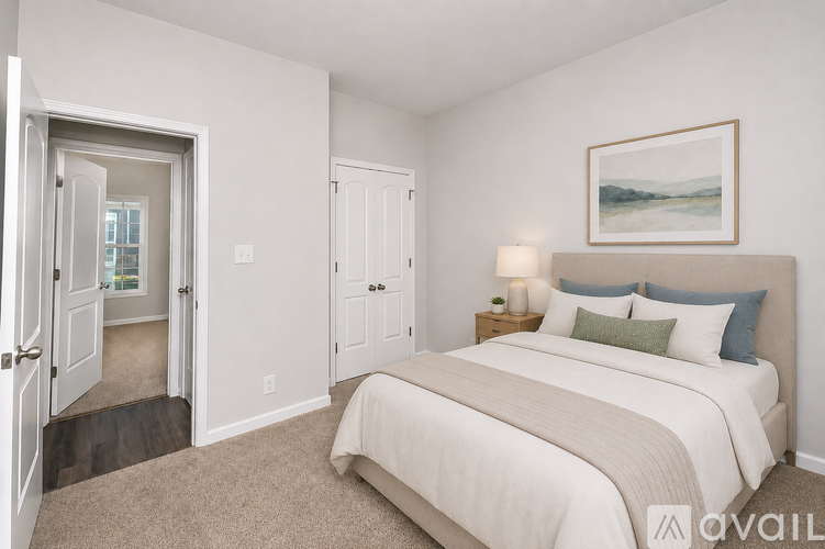 A bedroom with a large bed and a painting on the wall.
