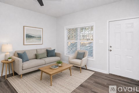 A living room with a couch, chair, and a painting on the wall.