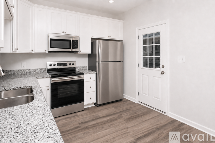 A kitchen with white cabinets and a granite countertop.