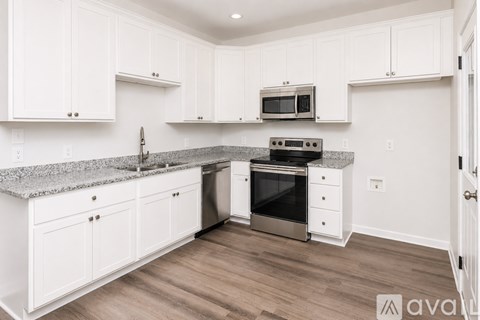 A kitchen with white cabinets and a granite countertop.