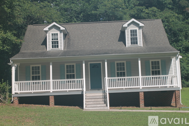 A house with a porch and a grey roof.