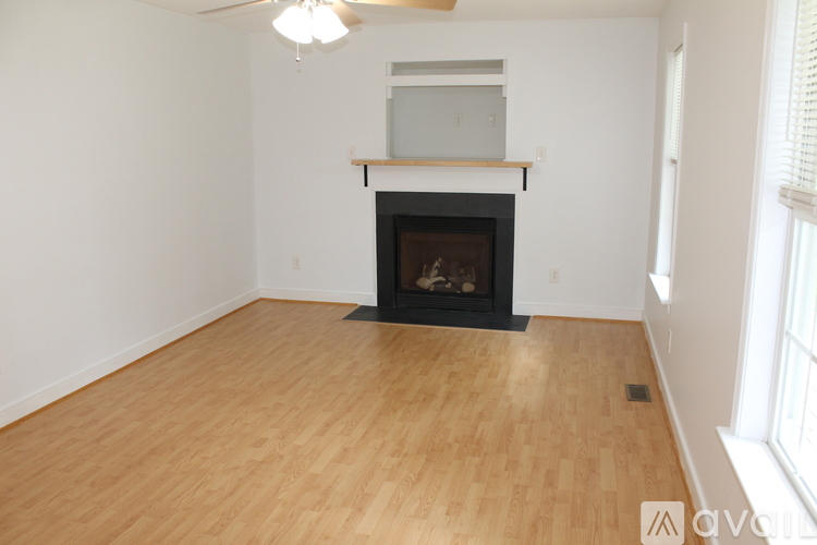 A living room with a fireplace and wood flooring.