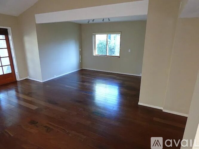 A room with wooden floors and a window.
