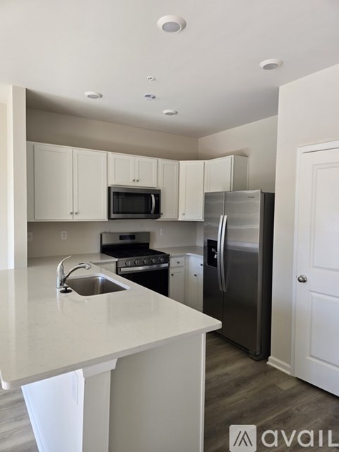 A kitchen with white cabinets and a white counter top.