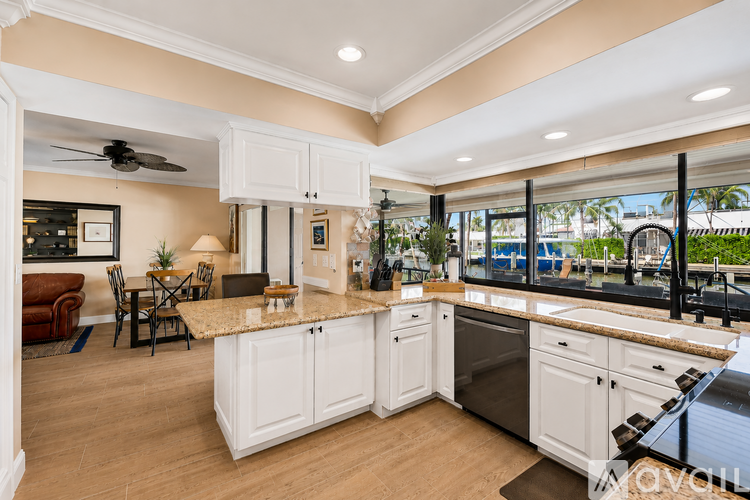 A kitchen with white cabinets and a granite countertop.