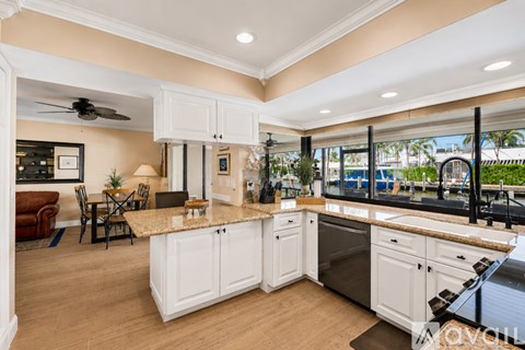 A kitchen with white cabinets and a granite countertop.