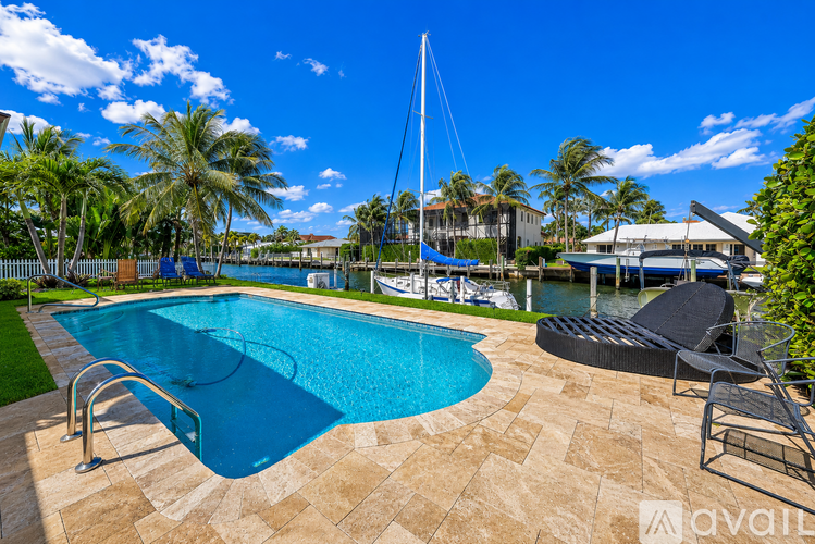 A swimming pool surrounded by a tiled floor and a chair.