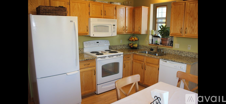 A kitchen with wooden cabinets and a white refrigerator.