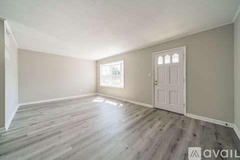 A room with a wooden floor and a white door.
