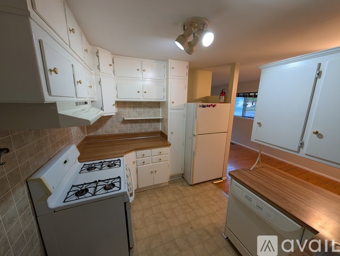 A kitchen with white cabinets and a wooden countertop.