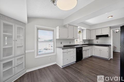 A spacious kitchen with white cabinets and a large island.