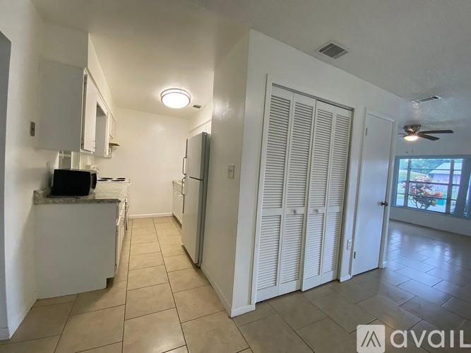 A kitchen with white cabinets and a refrigerator.