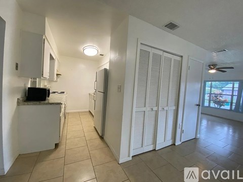 A kitchen with white cabinets and a refrigerator.