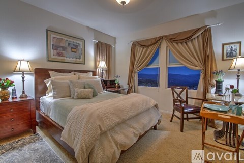 A bedroom with a large bed and a view of the ocean through the window.
