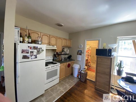 A kitchen with white appliances and wooden cabinets.