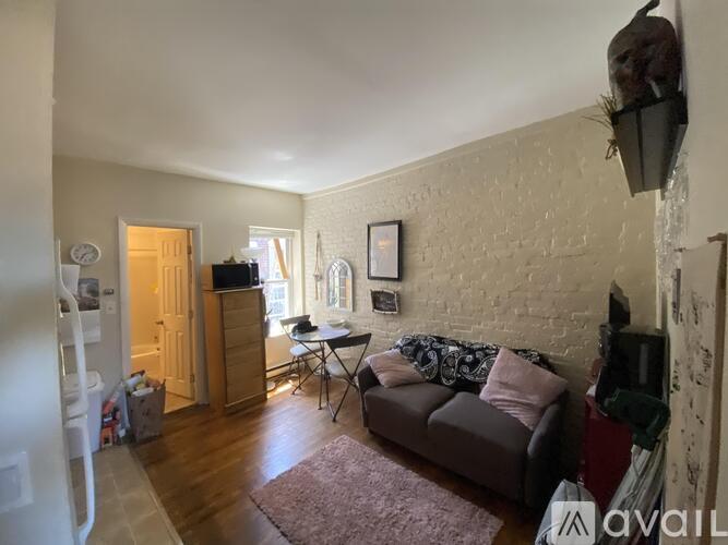 A living room with a couch, a chair, and a television.