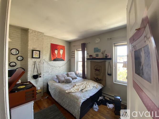 A bedroom with a bed, dresser, and a painting on the wall.