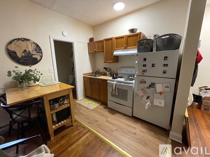 A kitchen with a refrigerator, oven, and sink.