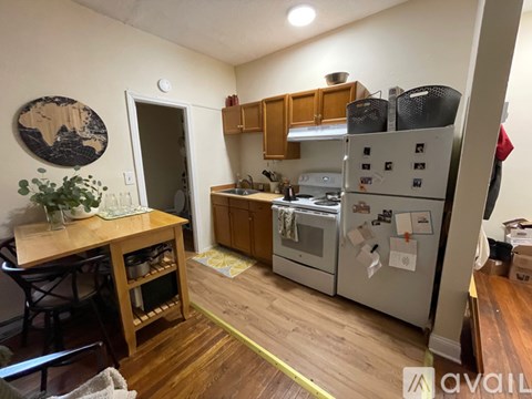 A kitchen with a refrigerator, oven, and sink.