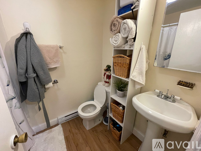 A bathroom with a toilet, sink, and towel rack.