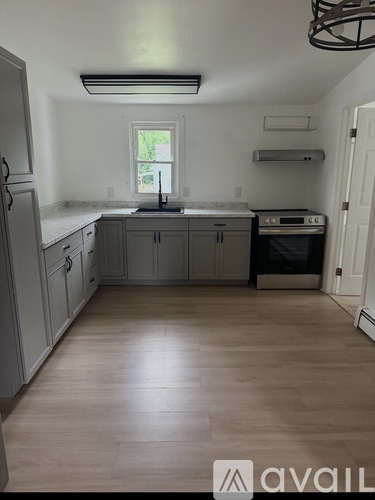 A kitchen with wooden floors and white walls.