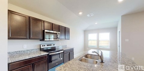 A kitchen with brown cabinets and a granite countertop.