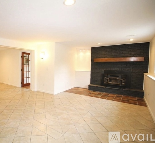 A living room with a fireplace and tiled flooring.