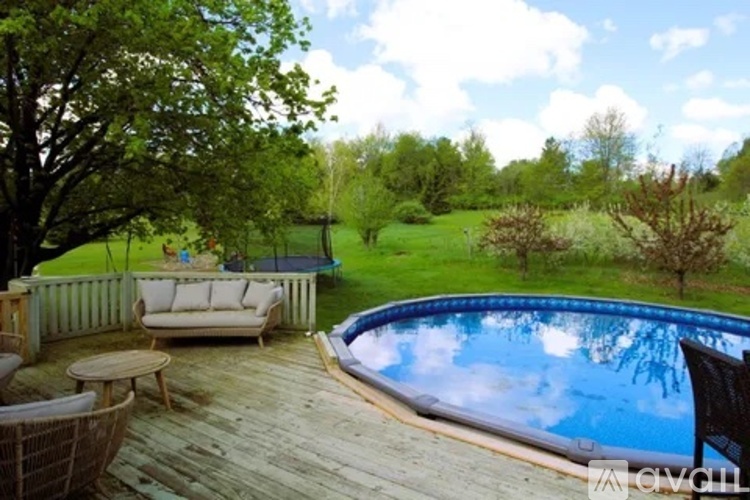 A wooden deck with a round pool and a white sofa.