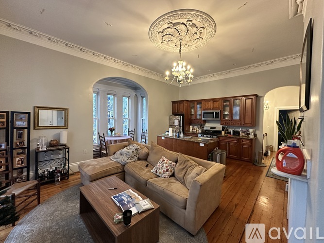 A living room with a couch, coffee table, and a chandelier.