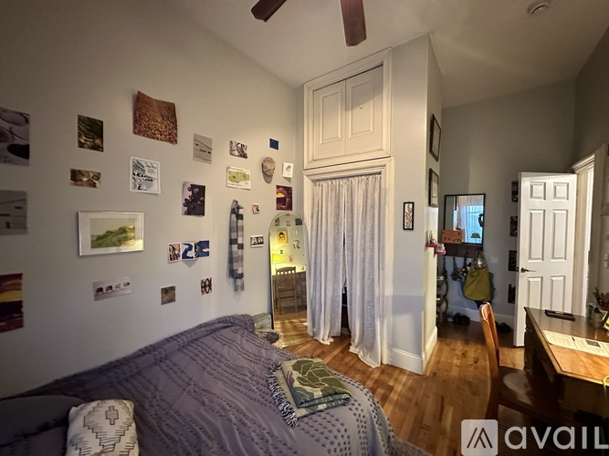 A bedroom with a bed, a desk, and a chair.