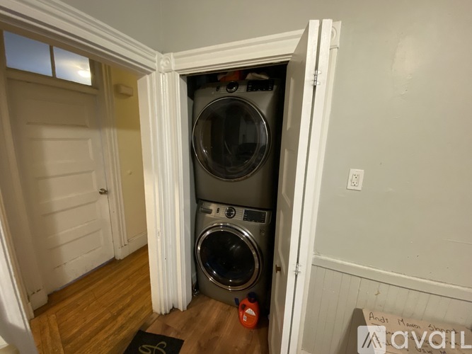 A washing machine is in a small alcove in a home.