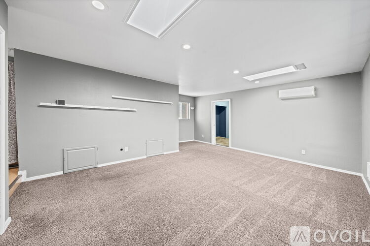 A spacious room with grey walls and carpeted floor.