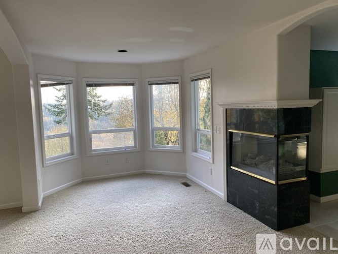 A living room with a fireplace and a carpeted floor.