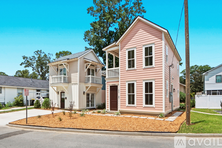 A two-story house with a pink exterior is for sale.