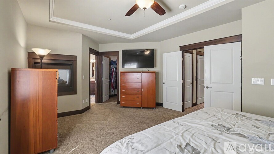 A bedroom with a large bed, a flat screen TV, and a wooden wardrobe.