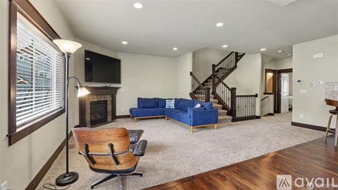 A living room with a blue couch and a wooden chair.
