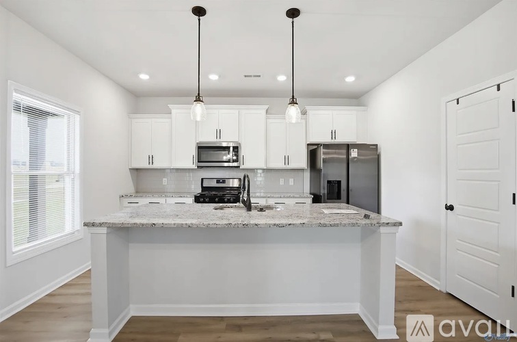 A kitchen with a granite countertop and white cabinets.