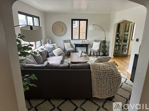 A living room with a grey couch and a white chair.