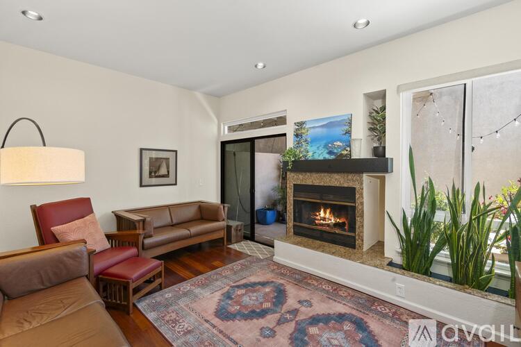 A living room with a fireplace and a painting on the wall.