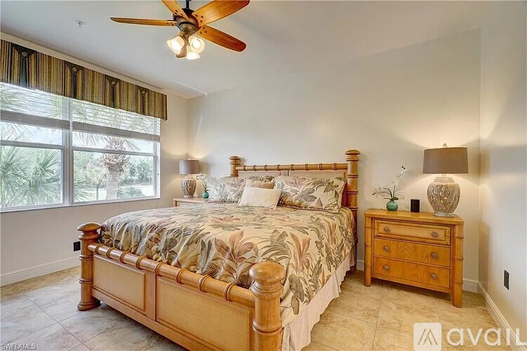 A bedroom with a large bed and a ceiling fan.