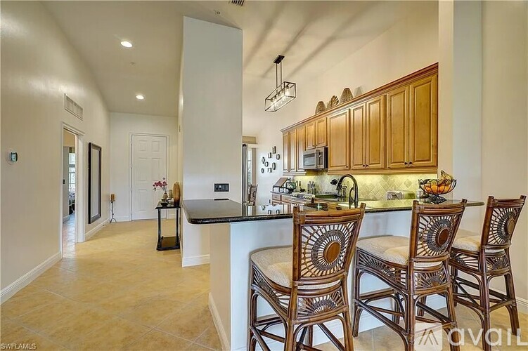 A kitchen with wooden cabinets and a black countertop.