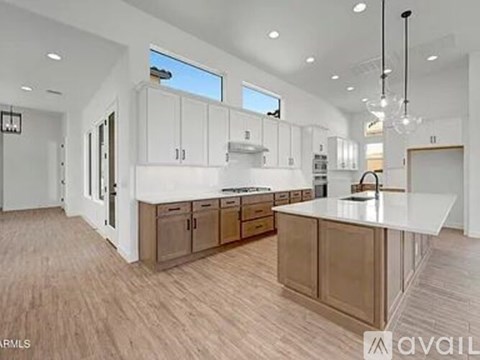 A spacious kitchen with white cabinets and a central island.