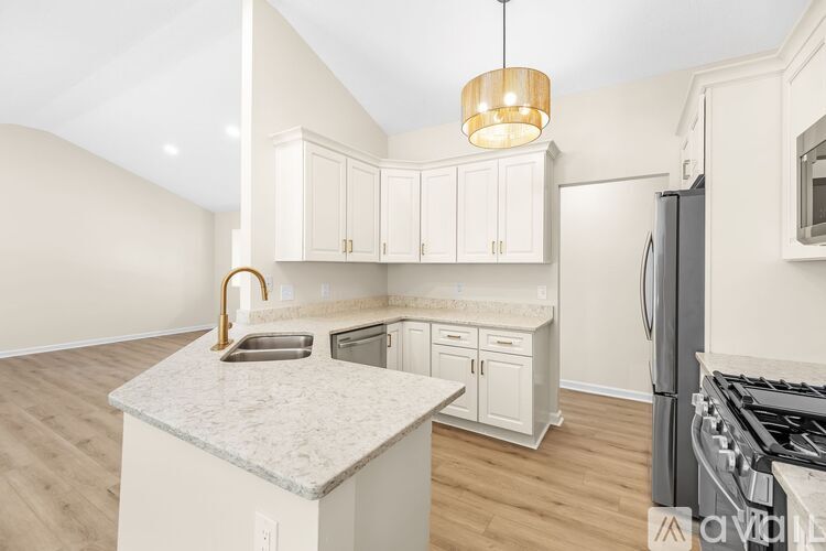 A kitchen with white cabinets and a marble countertop.