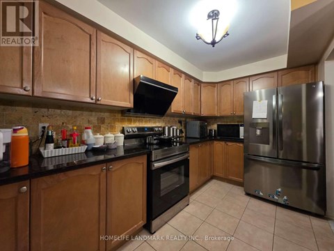 A kitchen with wooden cabinets and a stainless steel refrigerator.