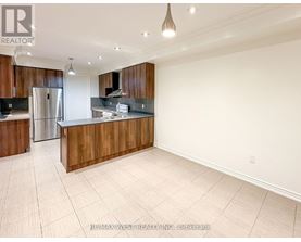 A spacious kitchen with wooden cabinets and a refrigerator.