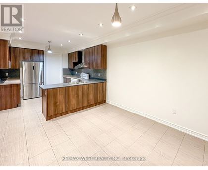 A spacious kitchen with wooden cabinets and a refrigerator.